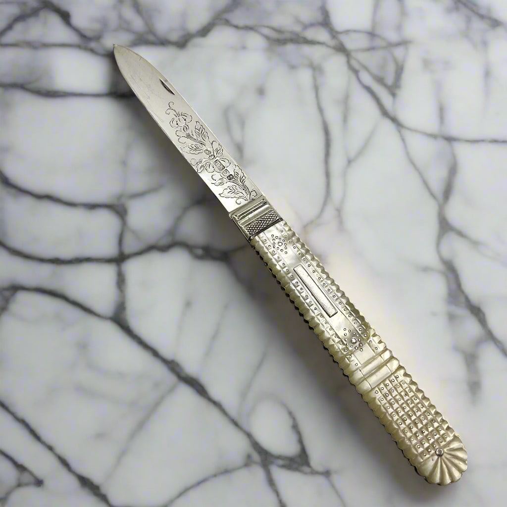 Antique silver fruit knife on a marble worktop