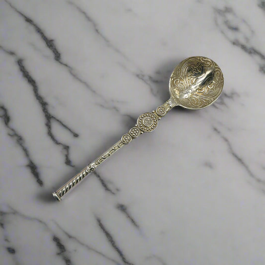 Decorative silver spoon on a marble worktop