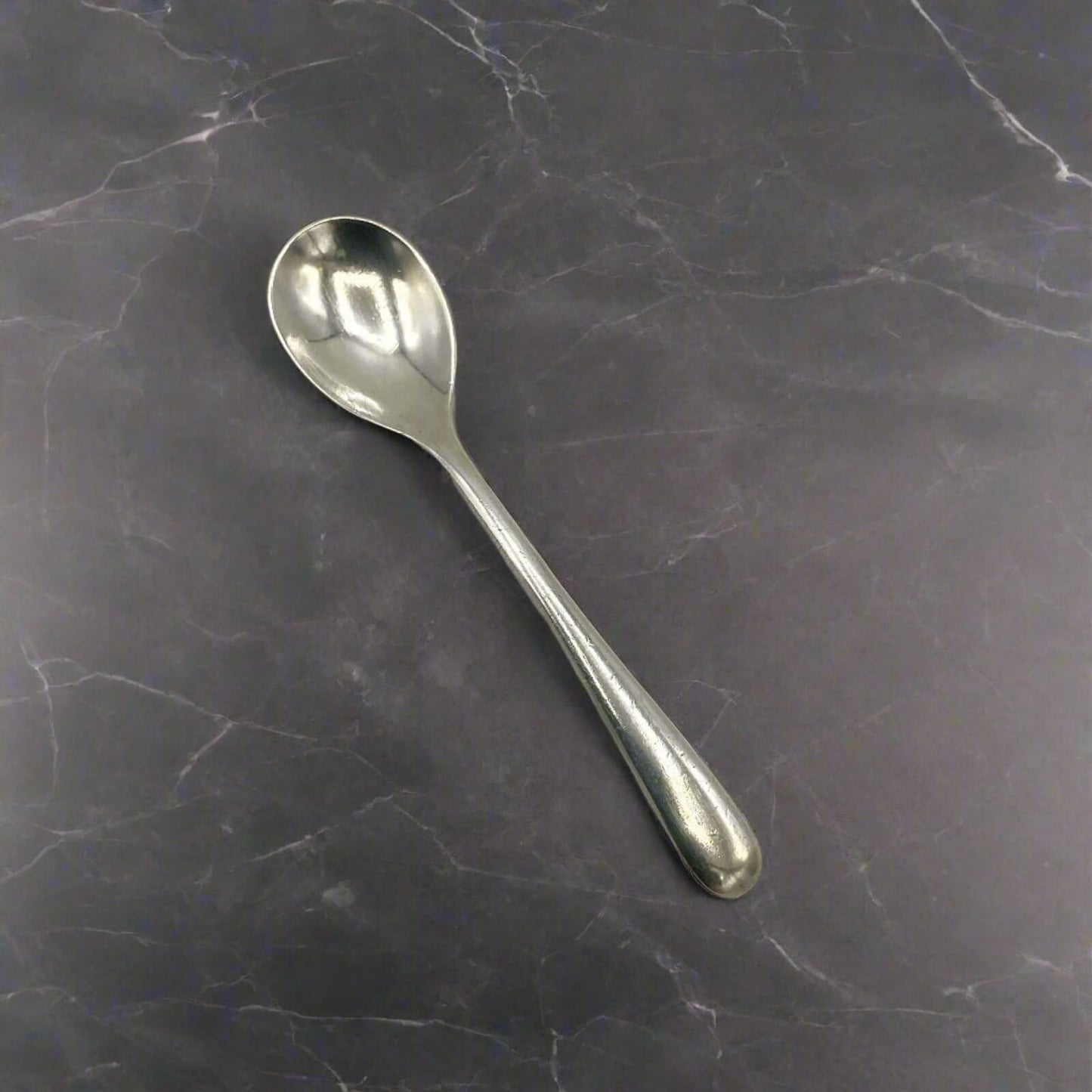 Silver spoon on a dark marble surface