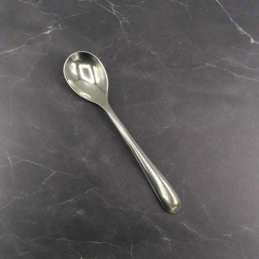 Silver spoon on a dark marble surface