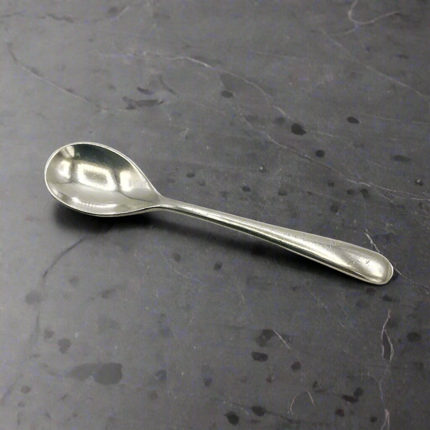 Silver spoon on a dark gray surface