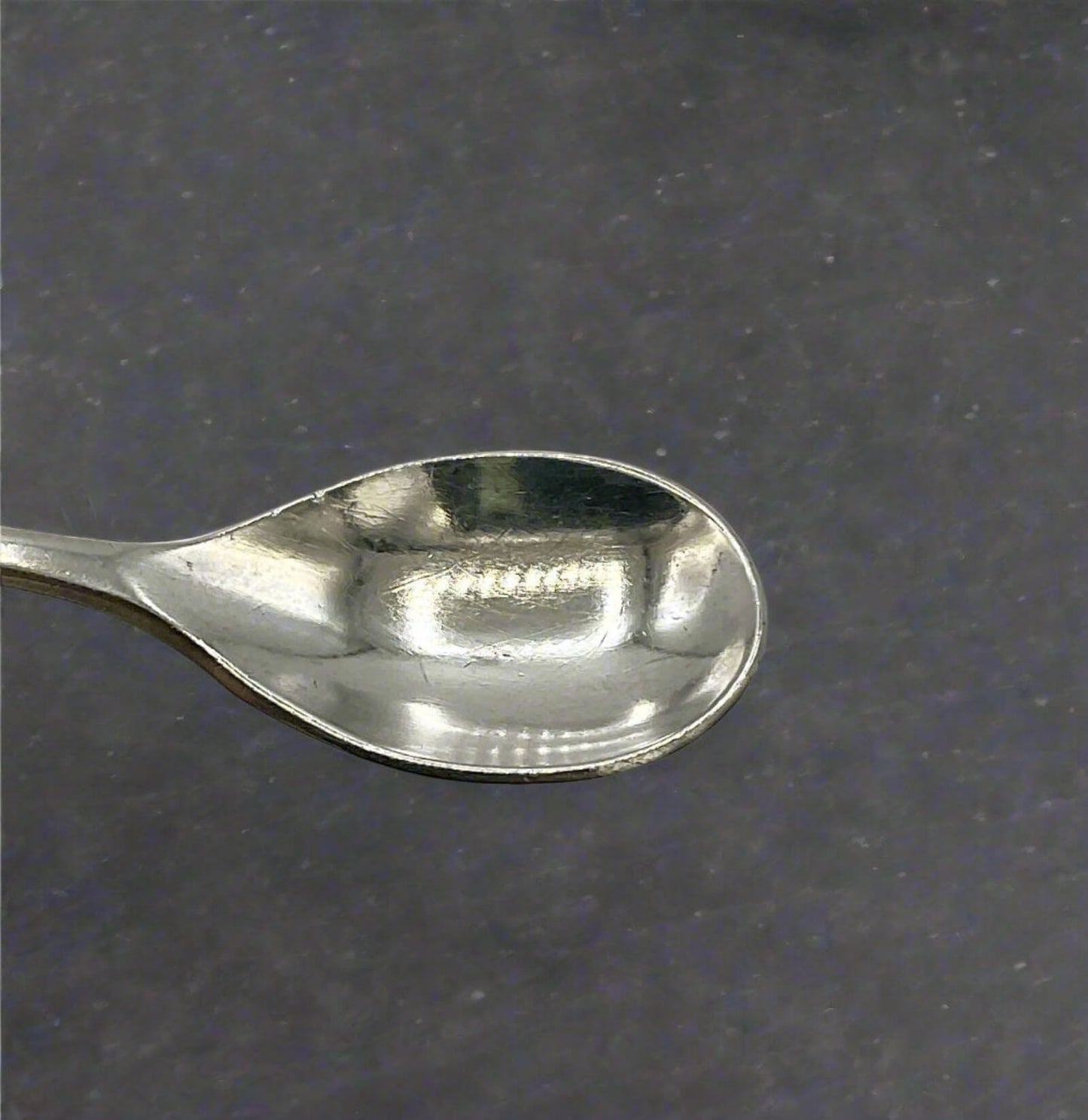 Silver spoon on a dark gray background