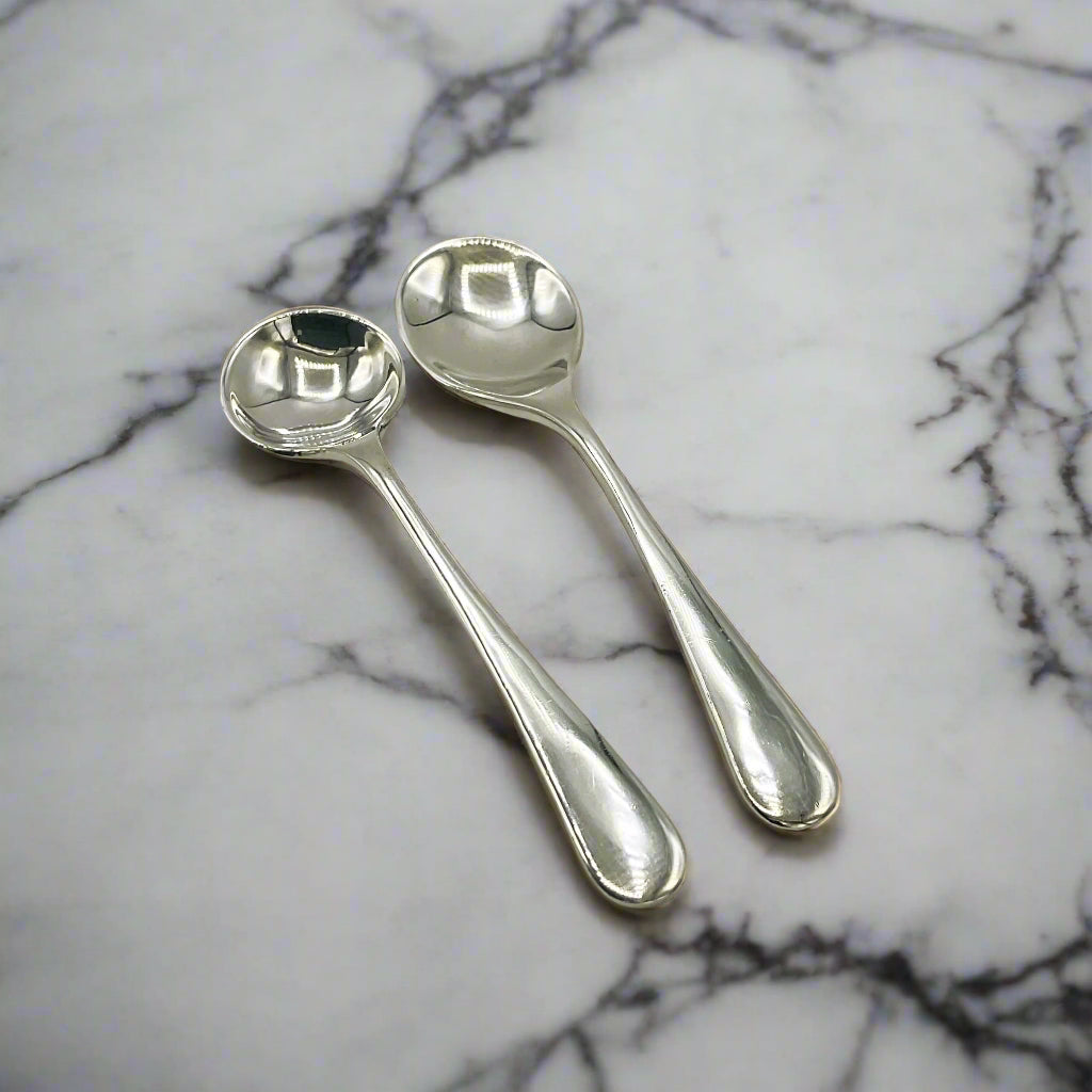 Two silver spoons on a marble workop