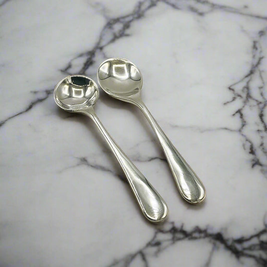 Two silver spoons on a marble workop
