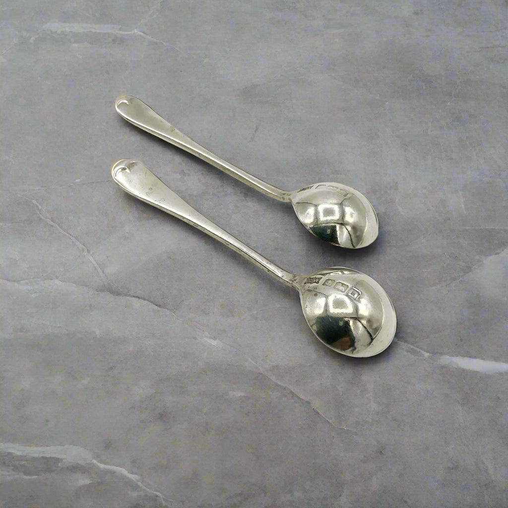 Two silver spoons on a light grey worktop