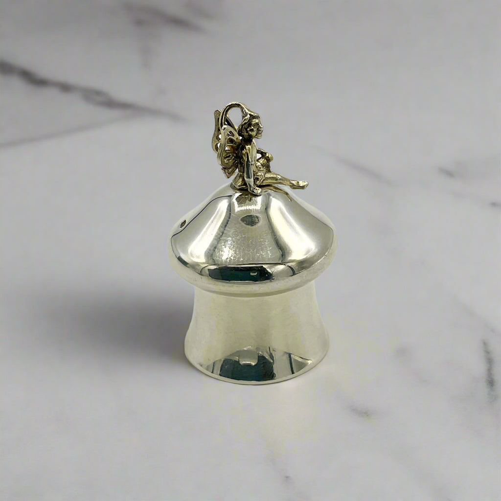 Silver pill box with a fairy figure on a marble background
