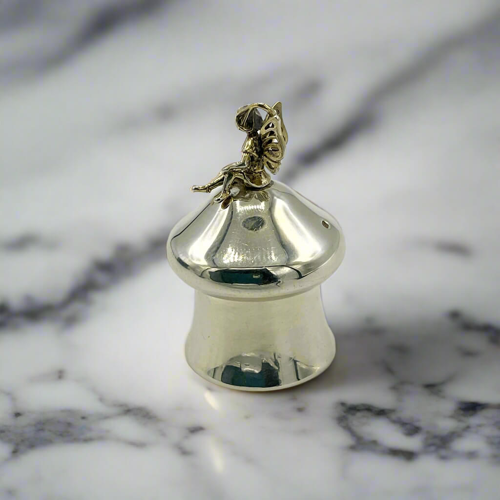 Gold and silver pill box on a marble surface