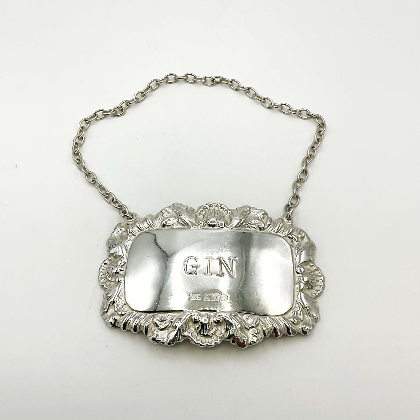 Silver gin label with chain on a white background