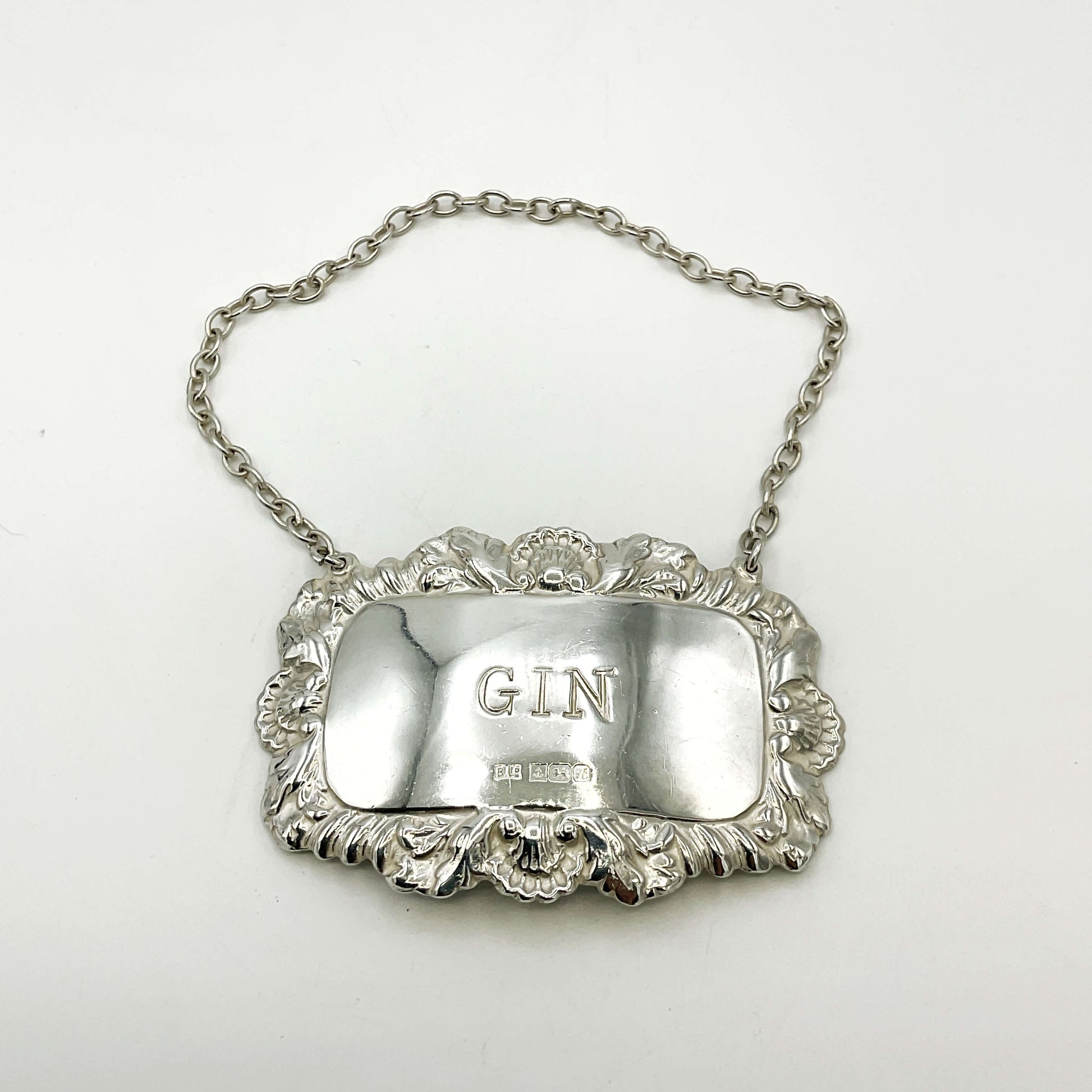 Silver gin label with chain on a white background