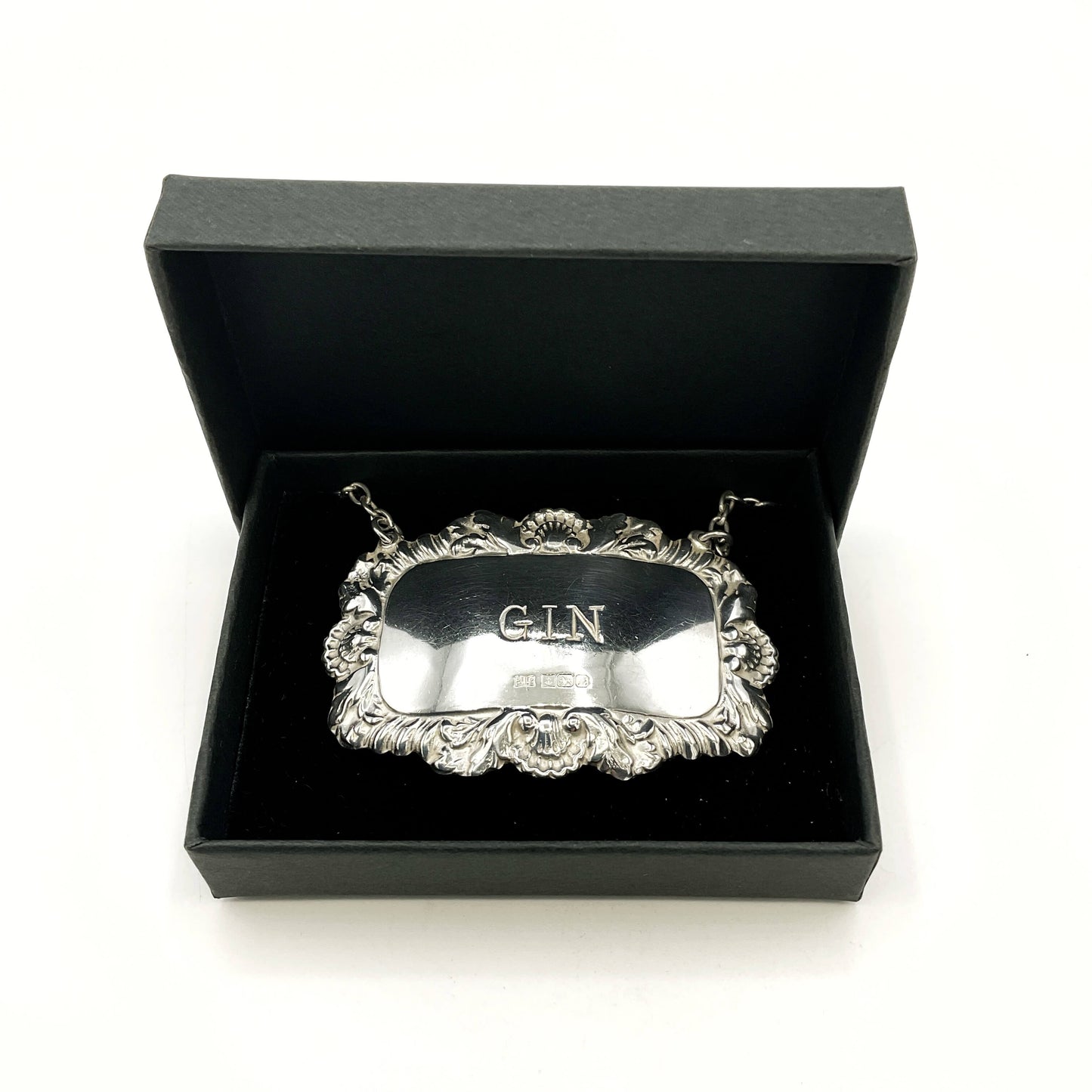 Silver 'GIN' label in a black box on a white background