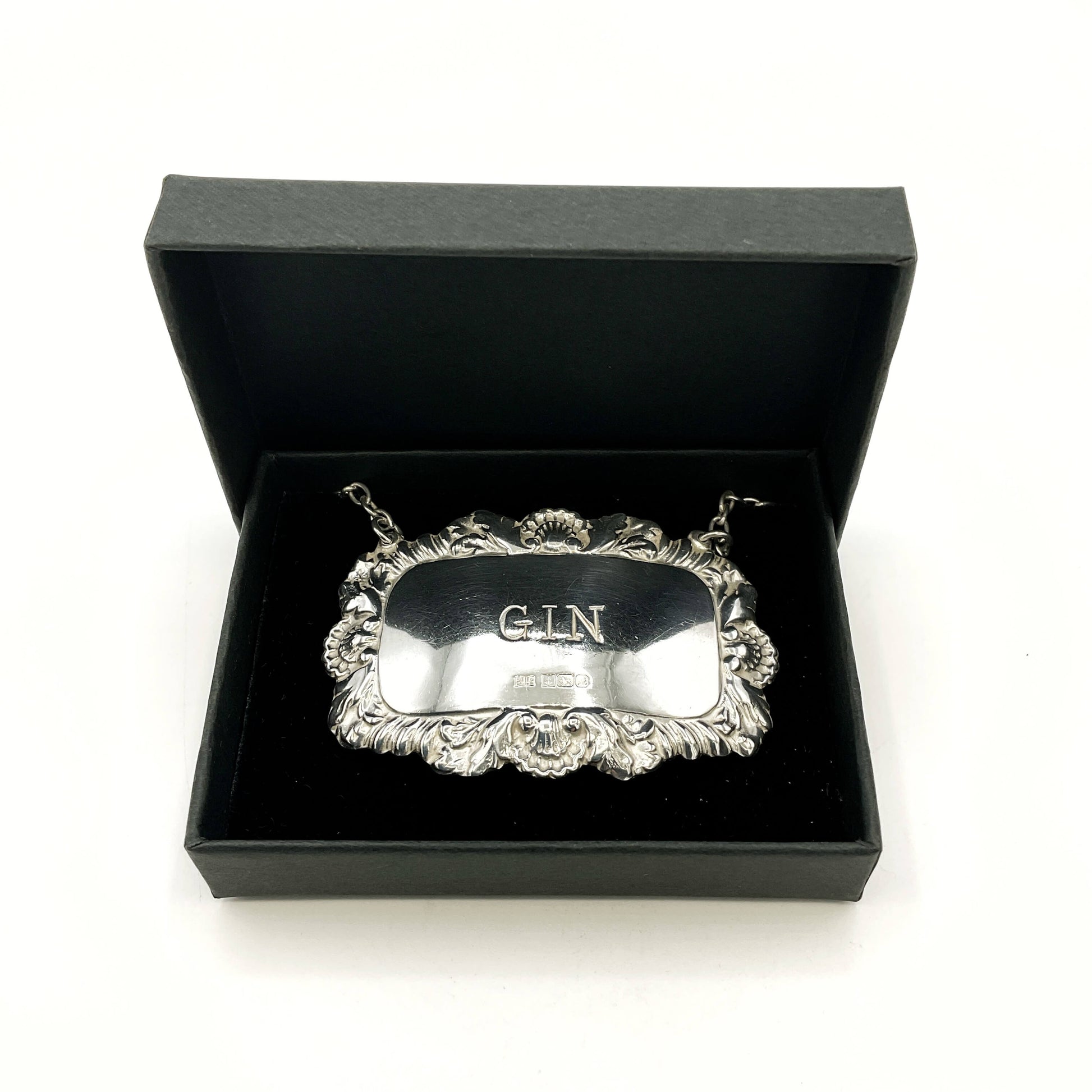 Silver 'GIN' label in a black box on a white background
