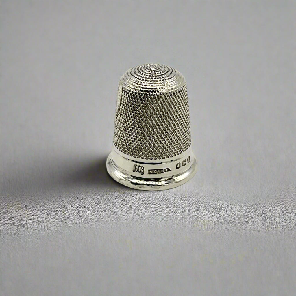 Silver thimble on a light  background