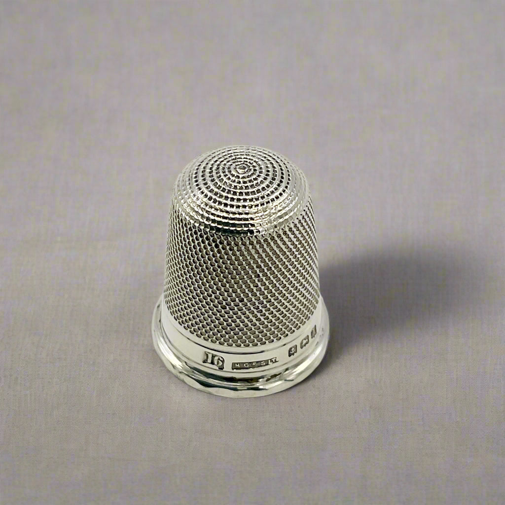 Silver thimble on a light background