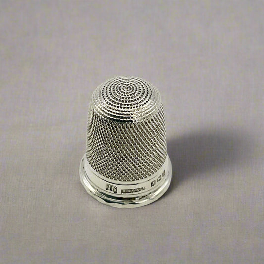 Silver thimble on a light background