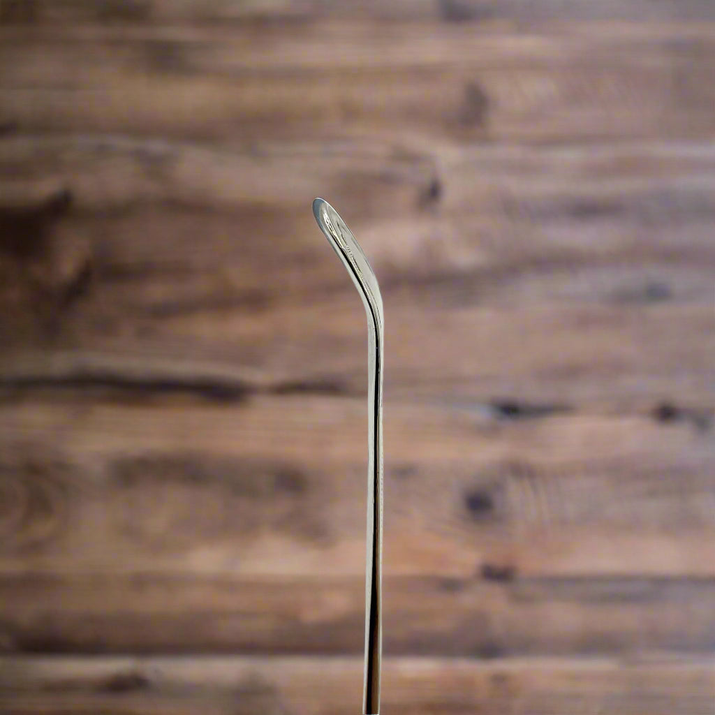 silver spoon handle with a wood table in the background