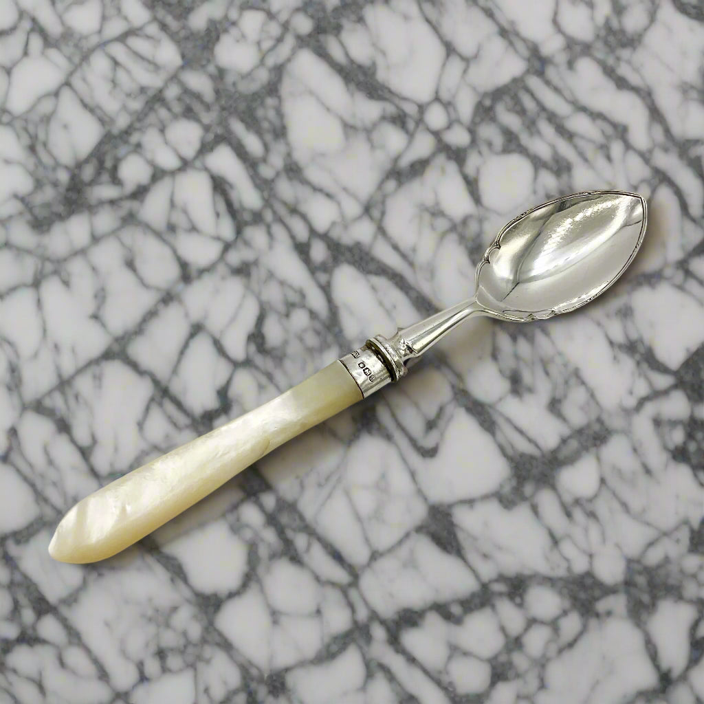 Spoon with a white handle on a mrble surface