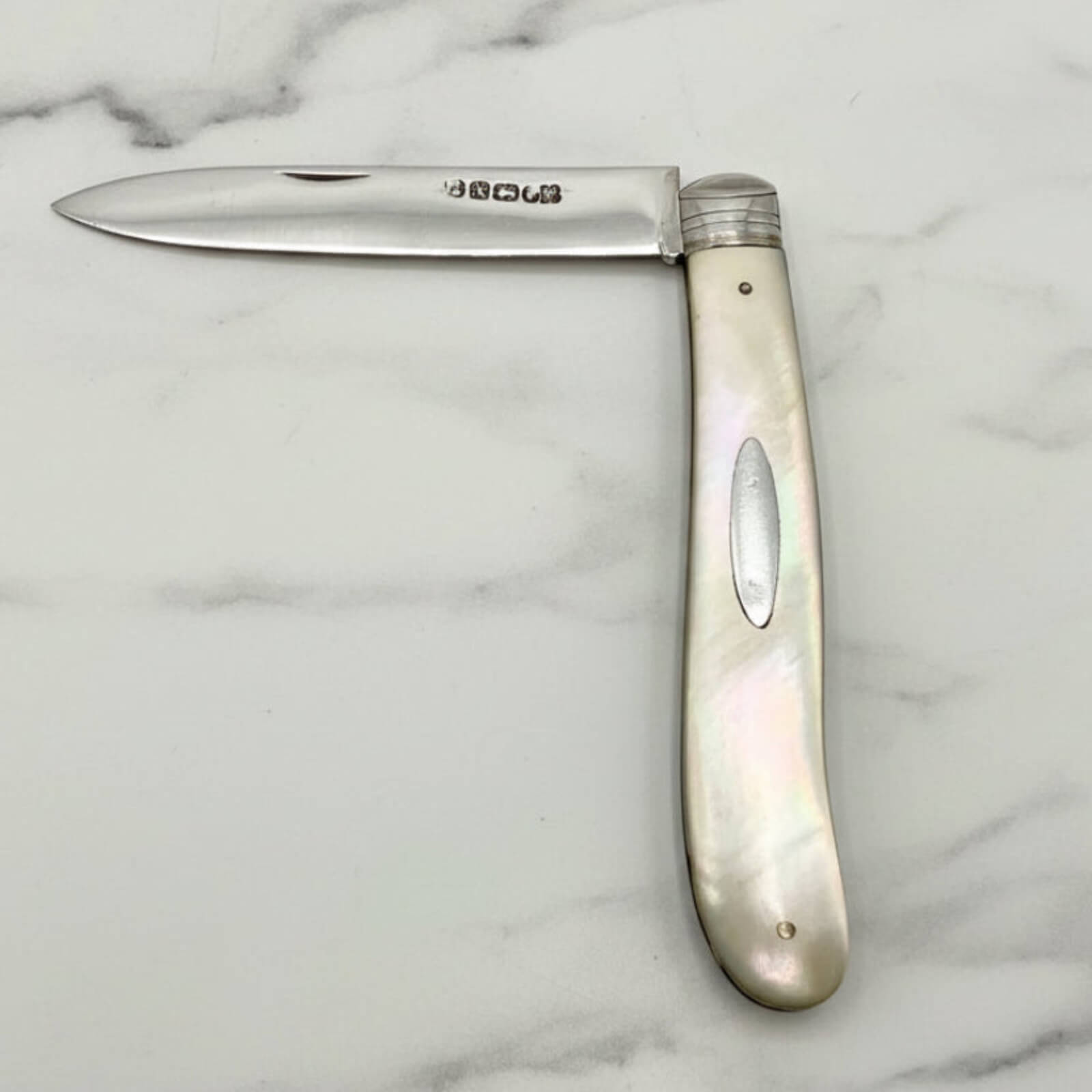 Folding knife with a decorative handle on a marble surface