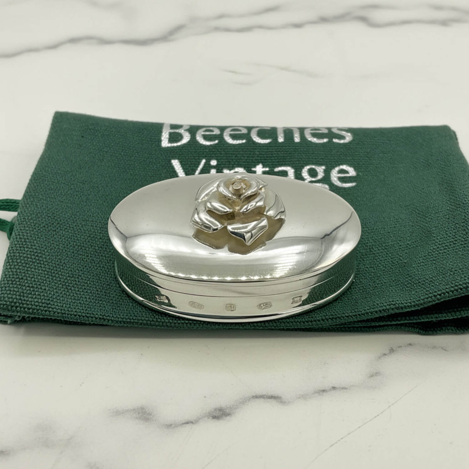 Silver pill box on cloth bag  with 'Beeches Vintage' branding.