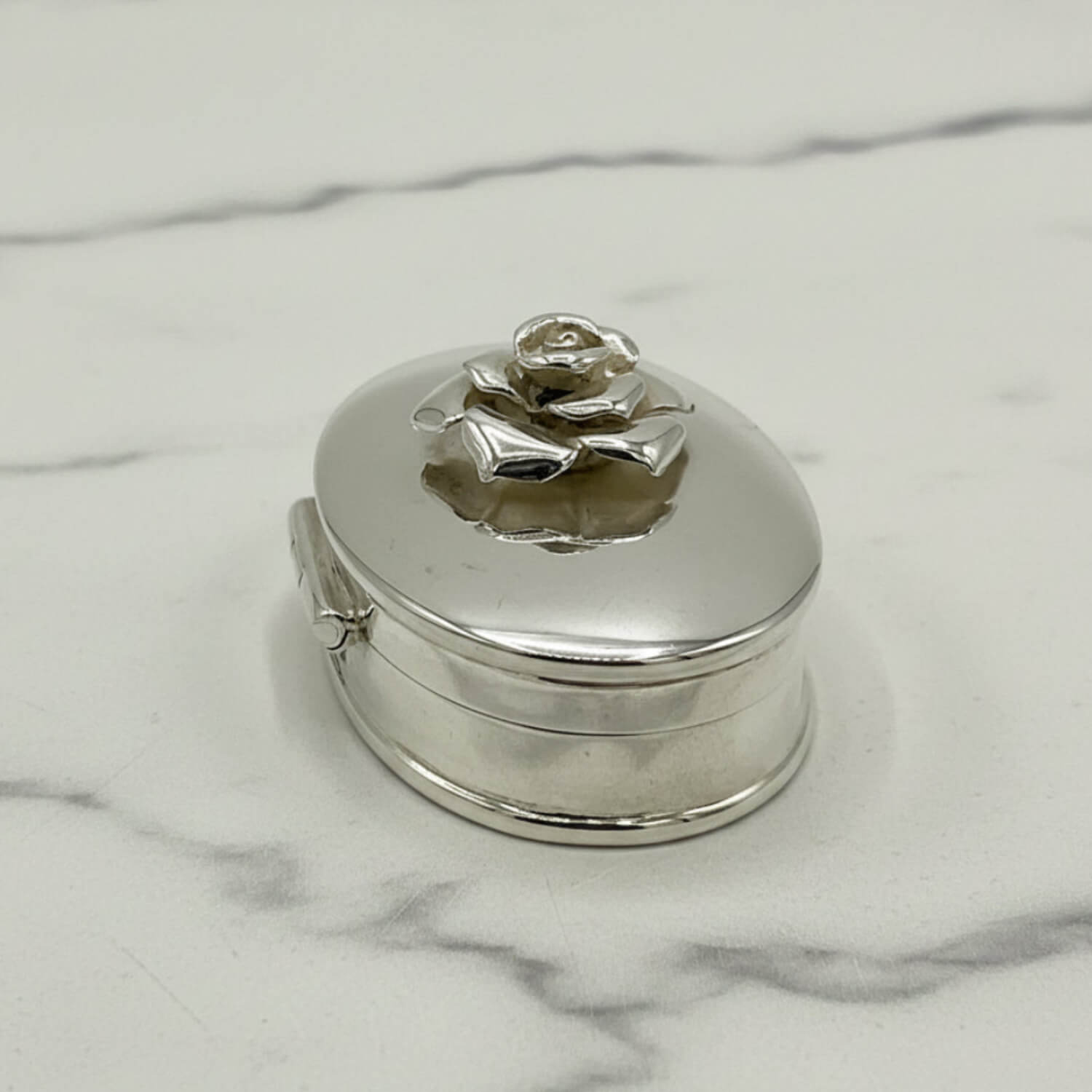 side view of Large Rose Sterling Silver Pill Box on a marble surface