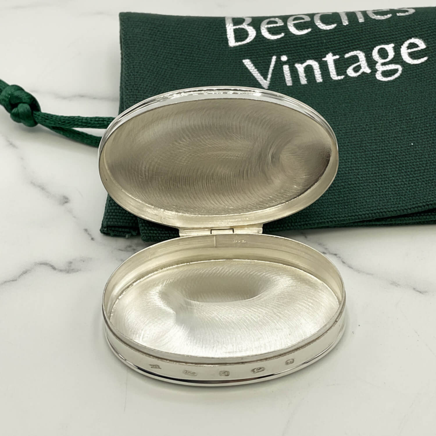 Large Rose Sterling Silver Pill Box interior with lid open on a marble surface and Beeches Vintage bag in the background