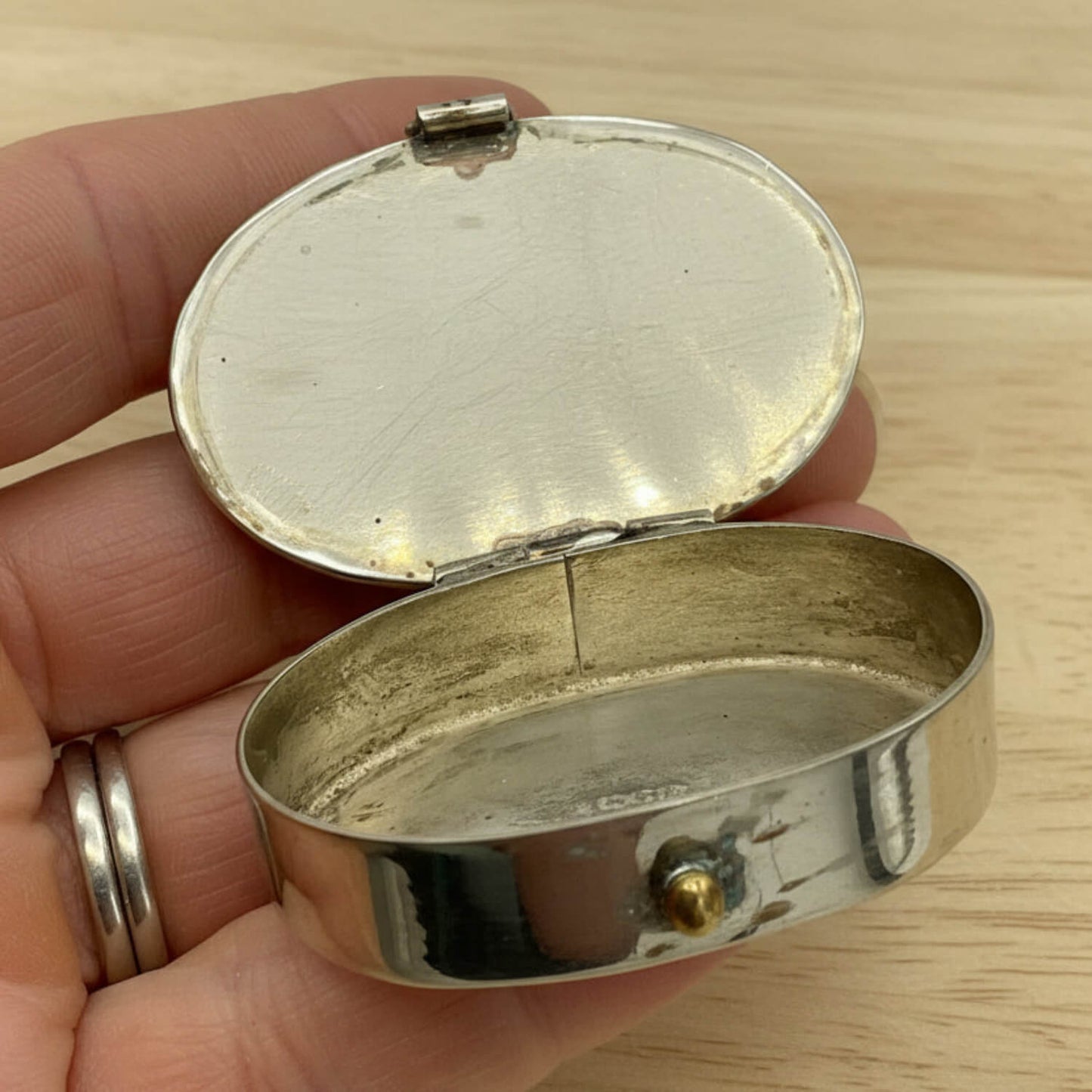 Mexican Abalone Shell Pill Box with open lid held in fingers