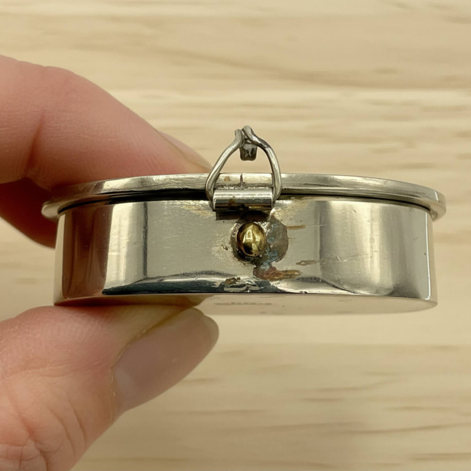 Mexican Abalone Shell Pill Box side view showing clasp held in fingers