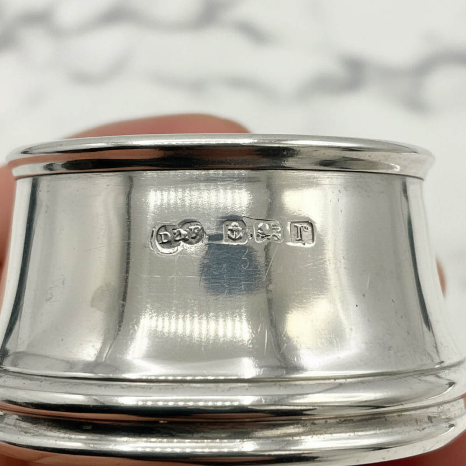 Silver salt with hallmarks on a marble surface