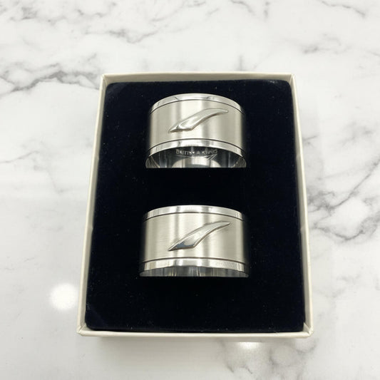 Pair of Concorde Sterling Silver Napkin Rings with a stylized wave design, presented in a black velvet-lined gift box on a white background.