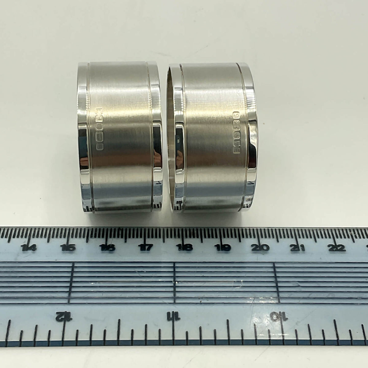 Pair of Concorde Sterling Silver Napkin Rings shown side-by-side on a white surface with a clear plastic ruler below for scale.