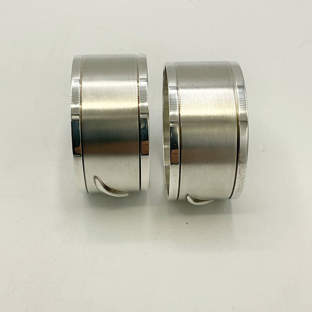 Pair of Concorde Sterling Silver Napkin Rings with a brushed and polished finish, displayed side-by-side on a plain white surface.