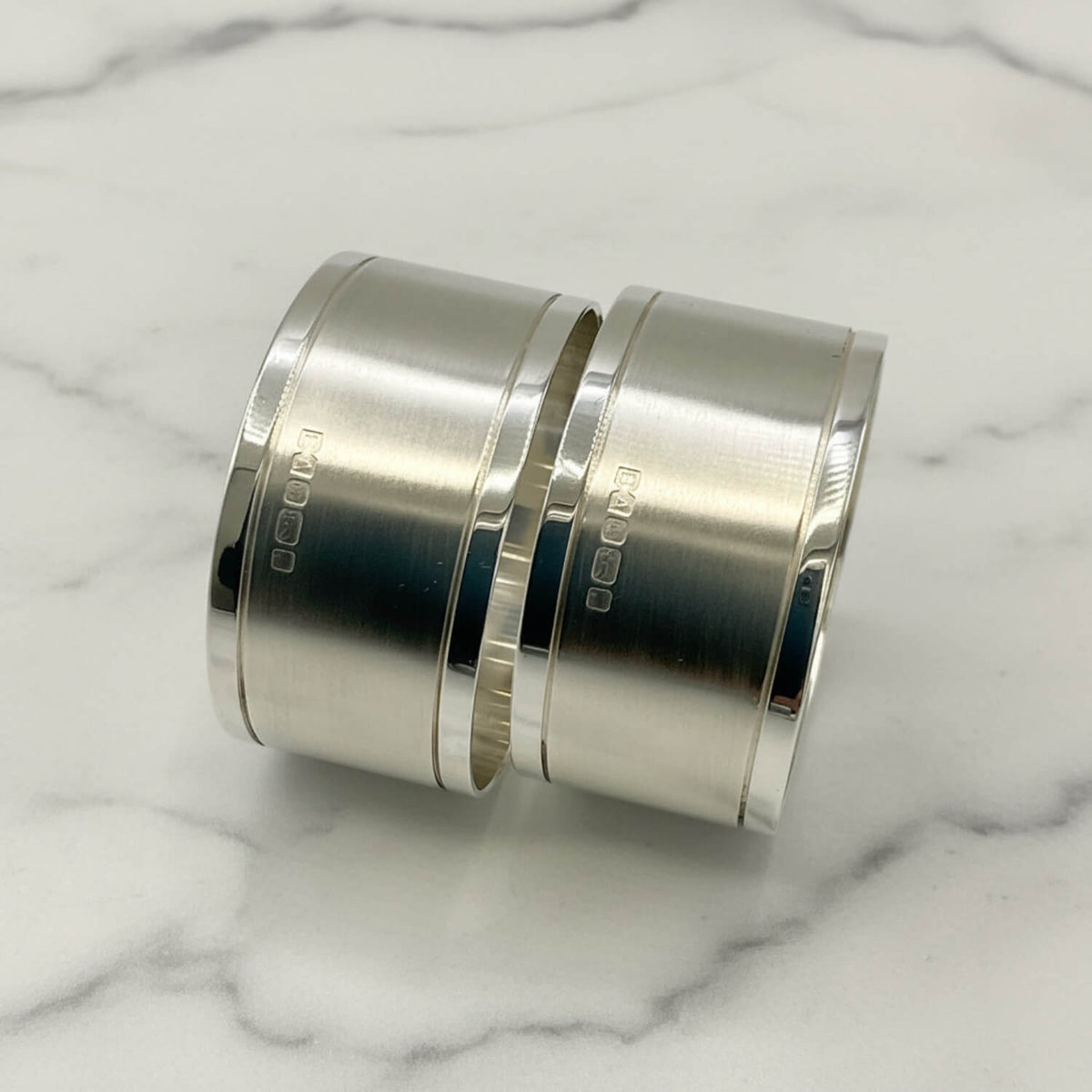 Pair of Concorde Sterling Silver Napkin Rings with a brushed and polished finish, shown on a plain light background.