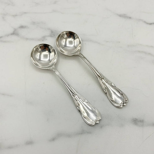 Two silver spoons on a marble surface