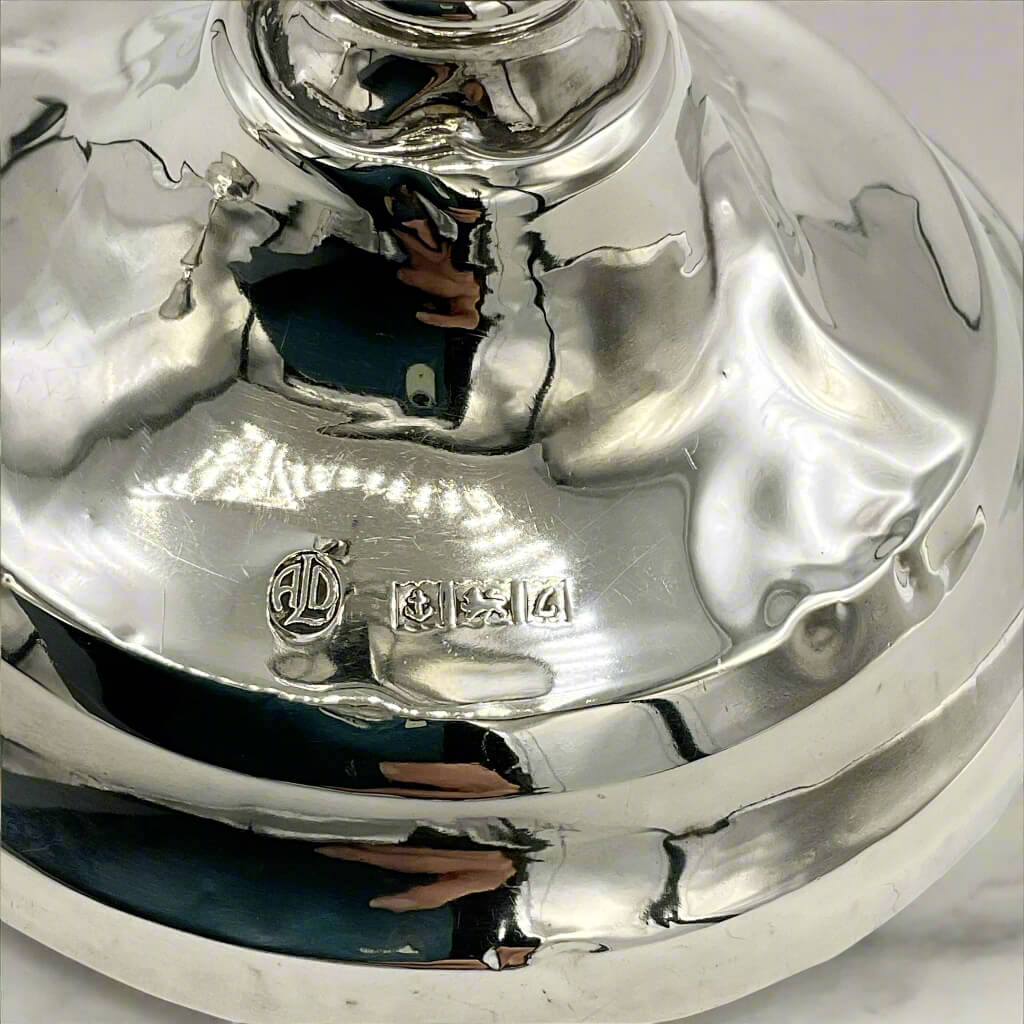 close up of hallmarks on a base of silver candlesticks engraving on a white background