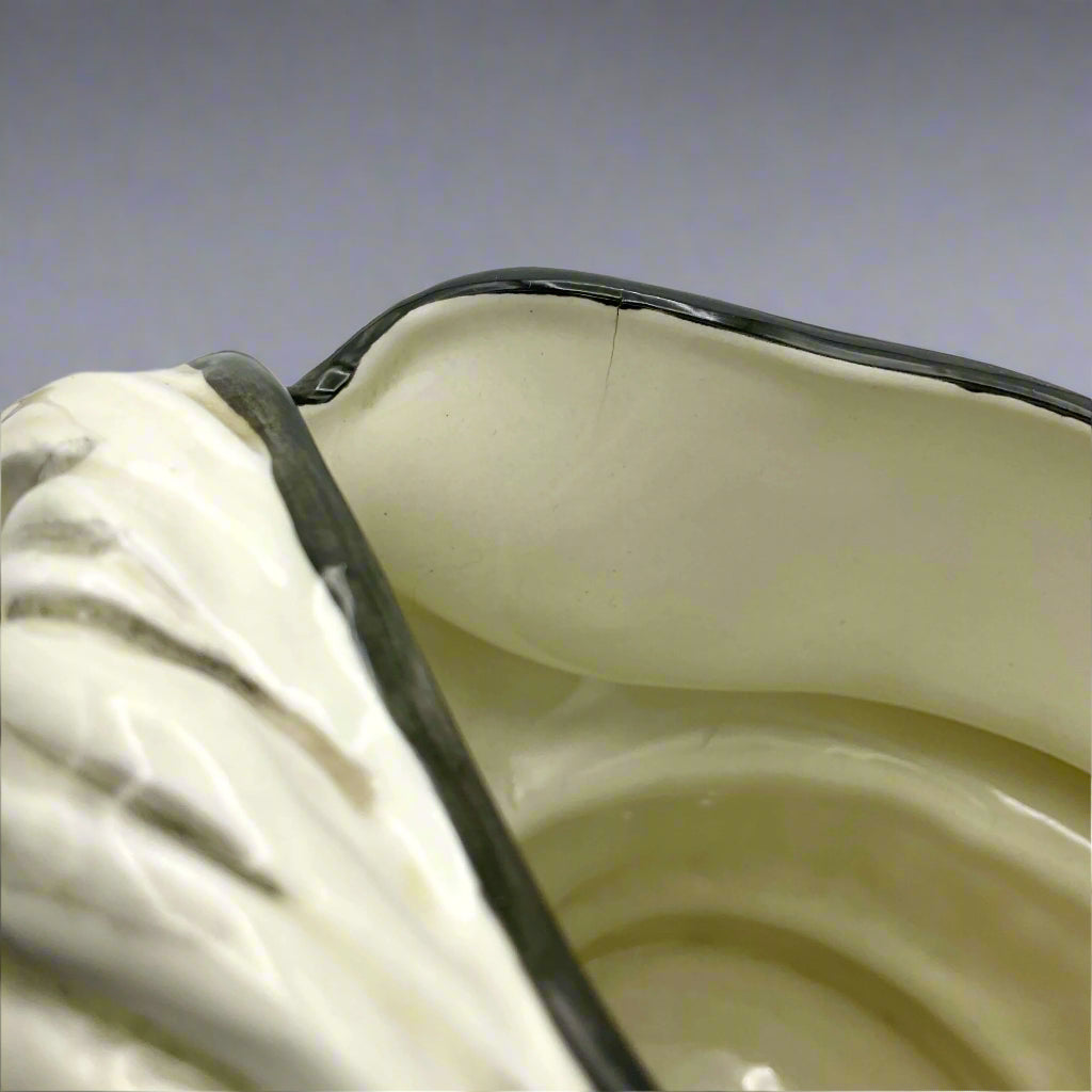 View of lip of Large Aramis China collectible toby jug on plain background.