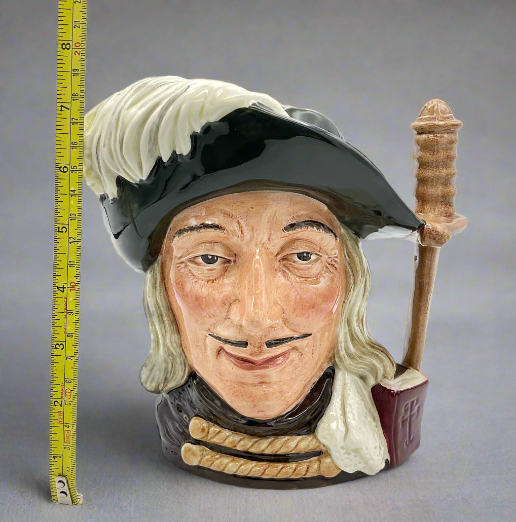 Large Aramis China collectible toby jug on plain background next to a tape measure.