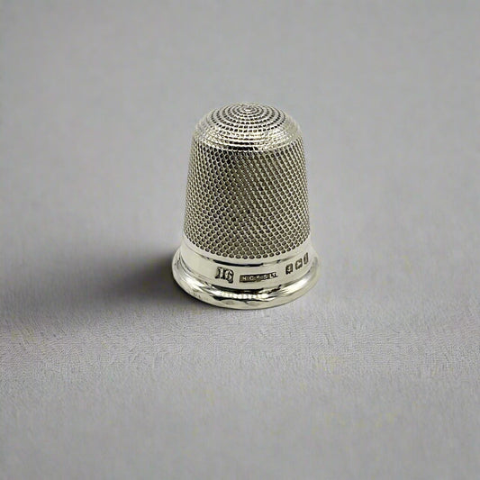 Silver thimble on a gray background