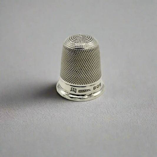 Silver thimble on a gray background