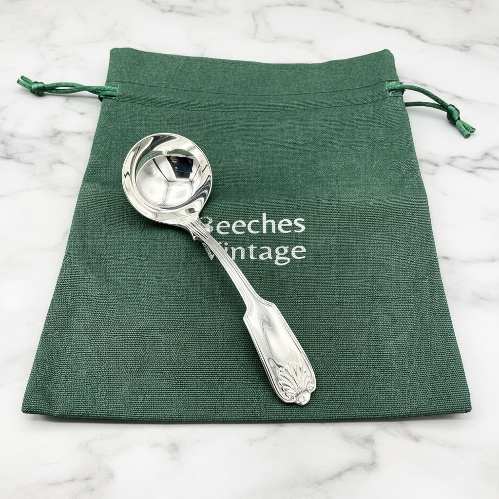 Silver plated ladle on a gift bag on a marble surface