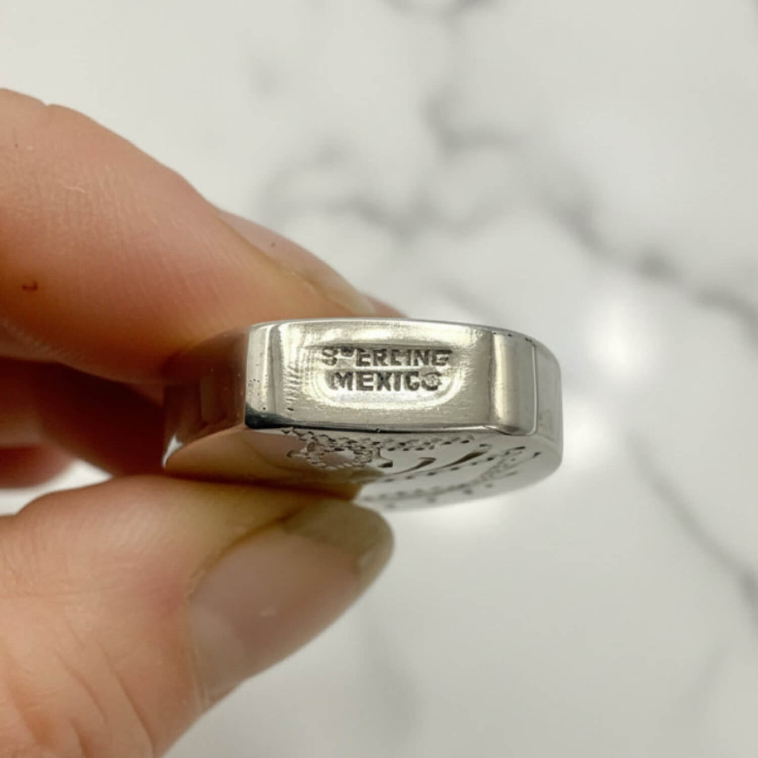 Small Sterling Silver Scent Bottle with Sterling Mexico engraving held between fingers against a neutral background