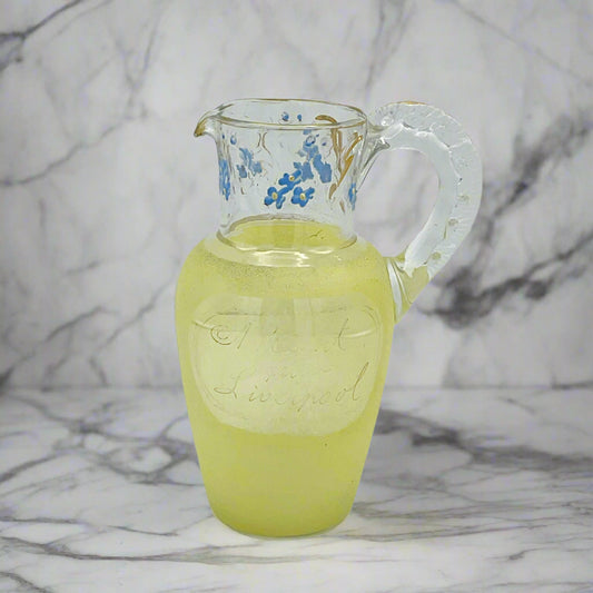 Clear glass pitcher with a yellow side on a marble surface