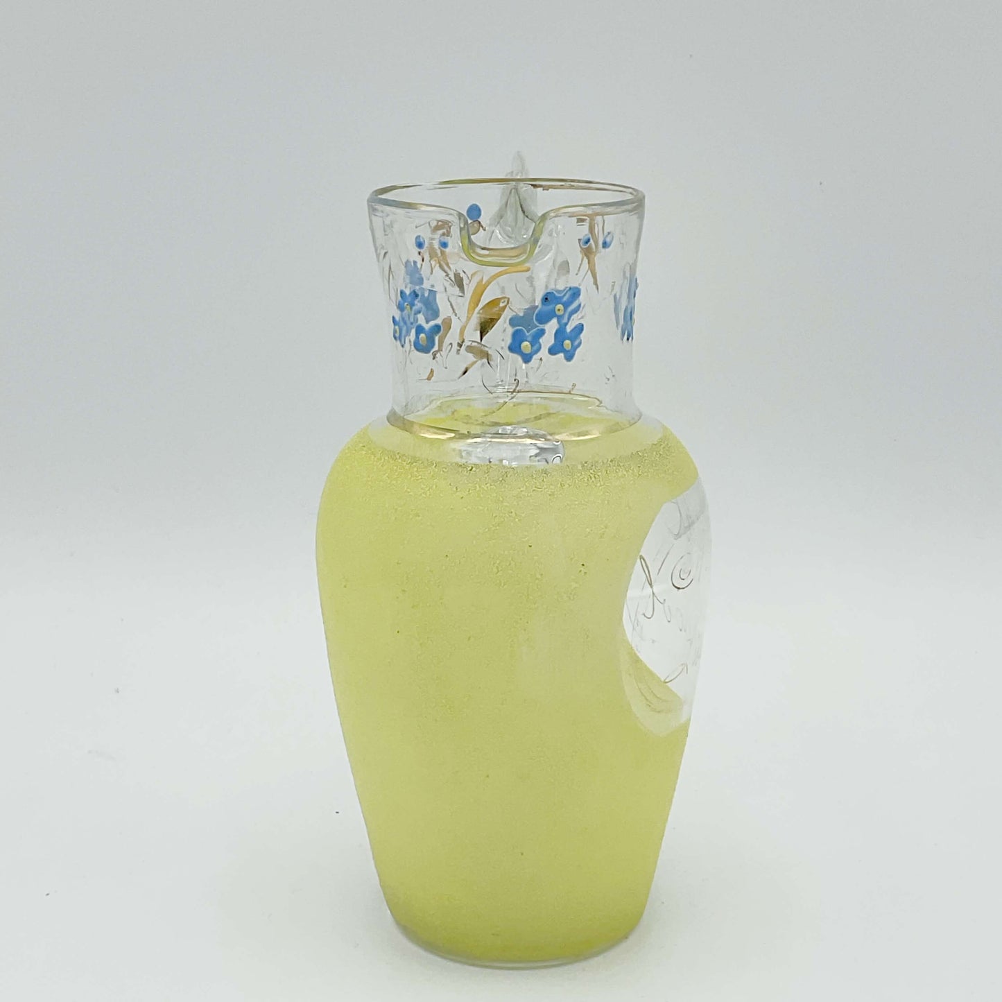 1950s glass jug with yellow sides and handpainted design at top on white background