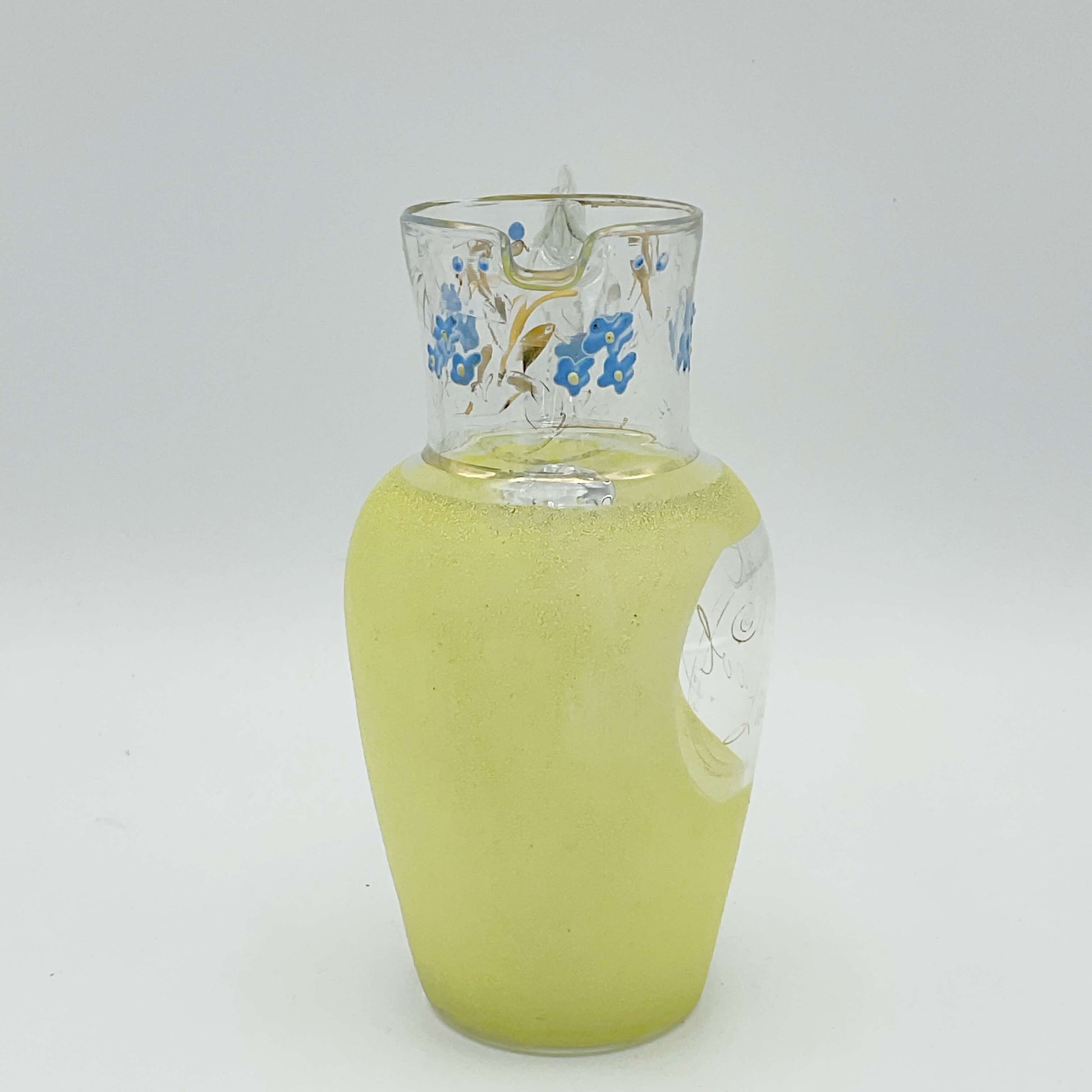 1950s glass jug with yellow sides and handpainted design at top on white background
