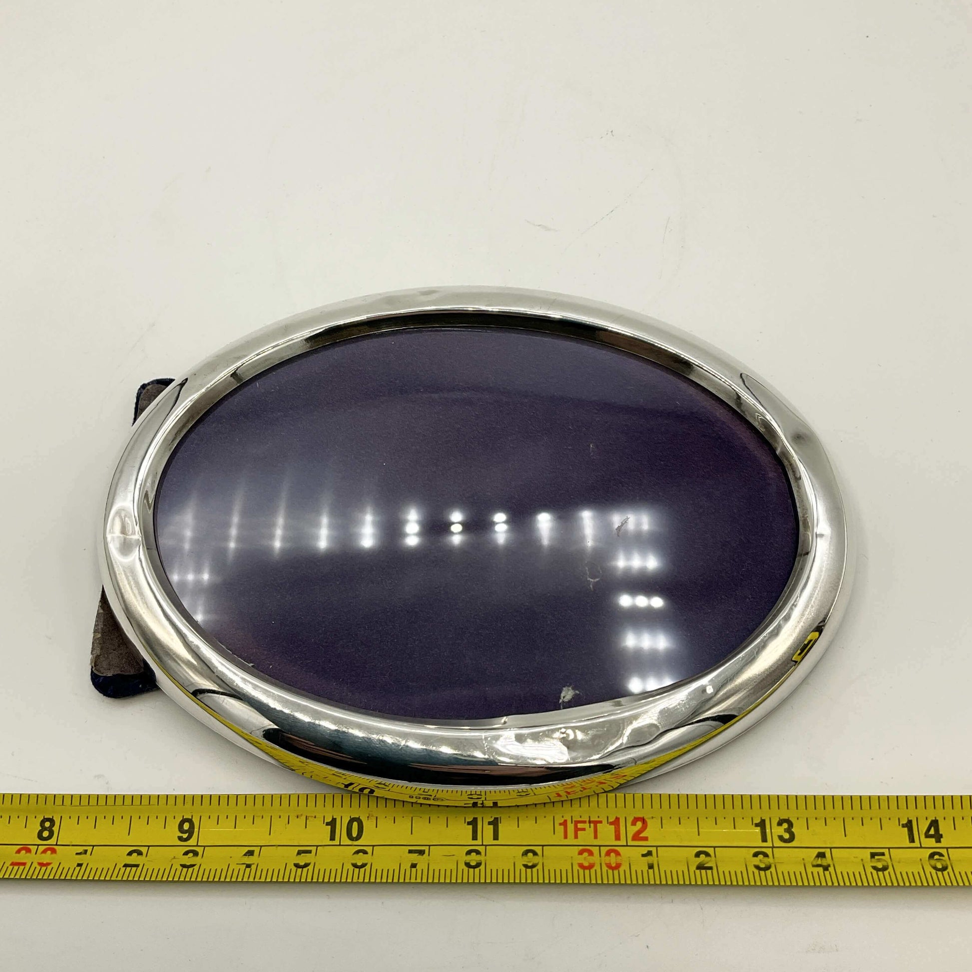 Sterling Silver Oval Photo Frame next to a tape measure for scale