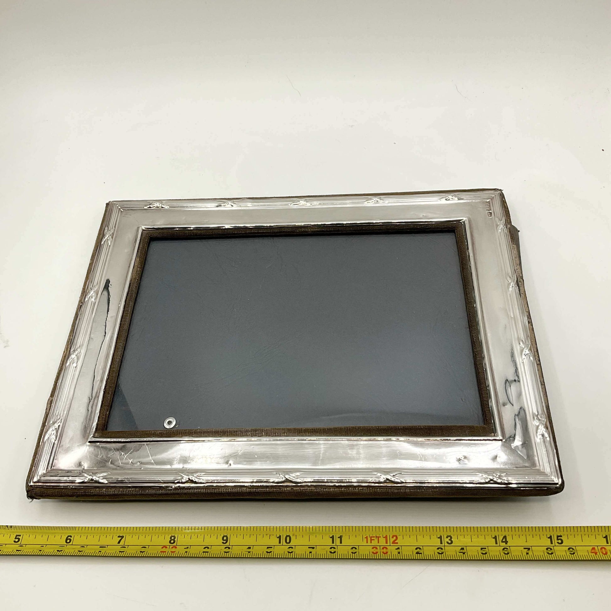 Sterling Silver Rectangular Photo Frame next to a measuring tape for scale on a white surface