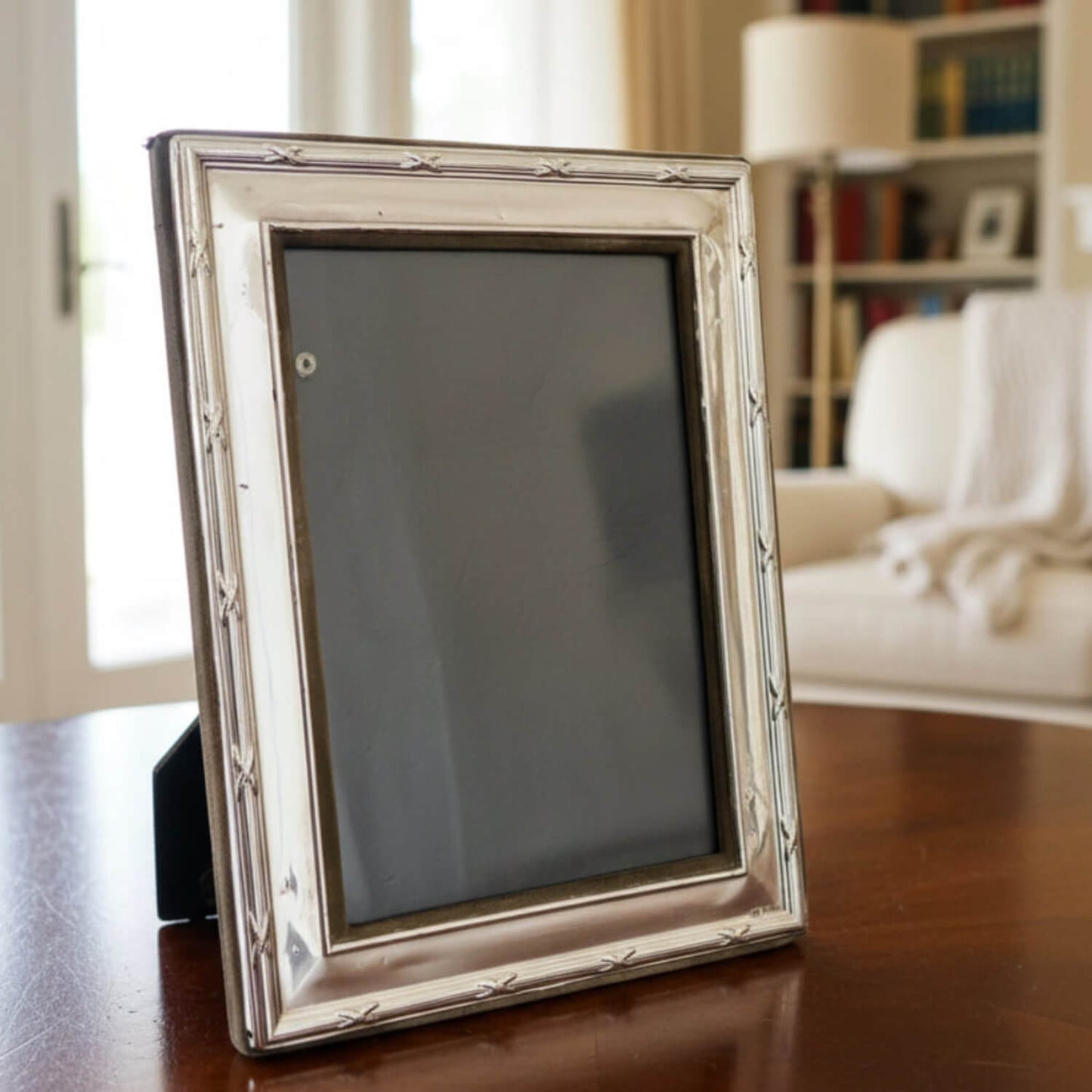 Silver photo frame on a wooden table with a blurred background