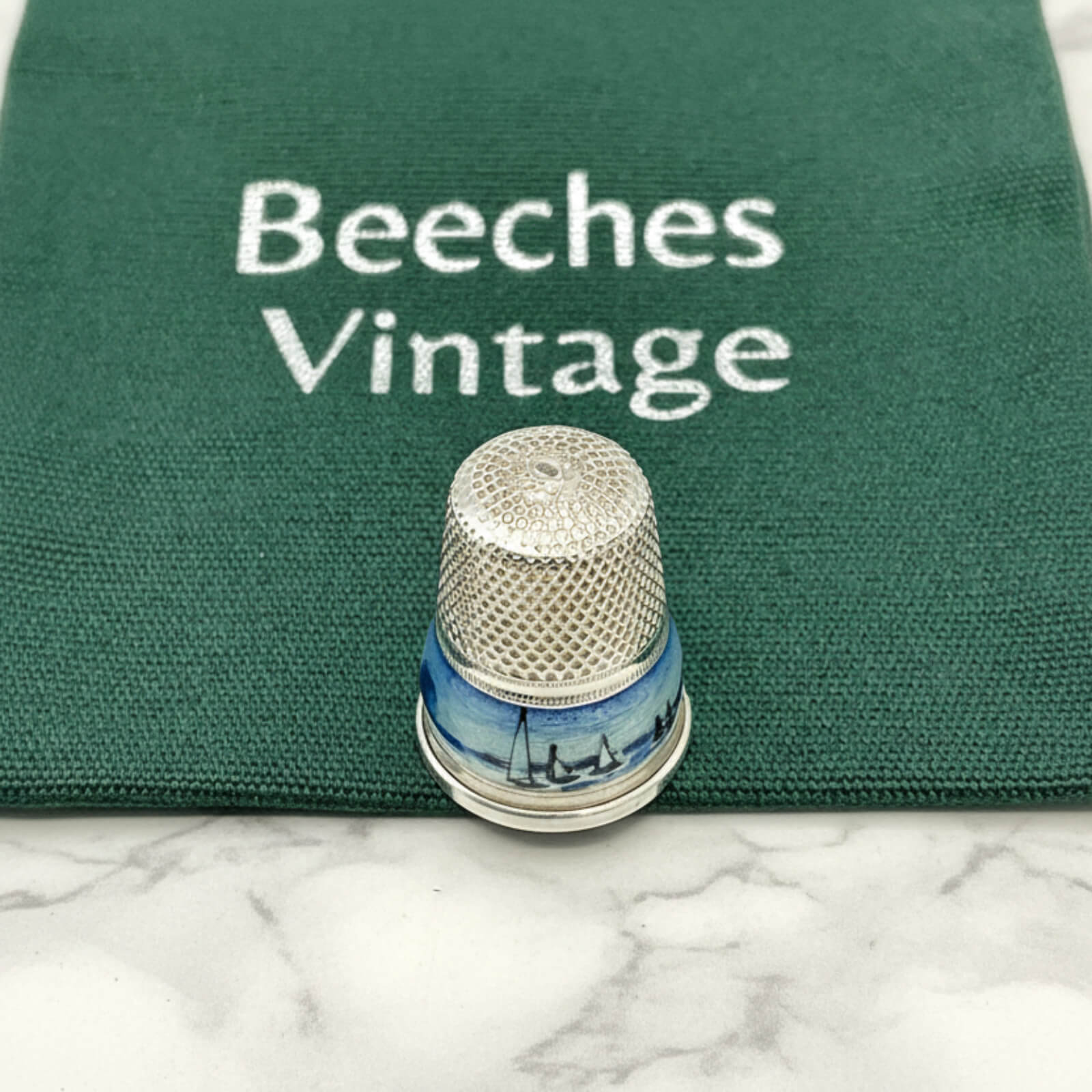 Silver thimble on a green bag with 'Beeches Vintage' text