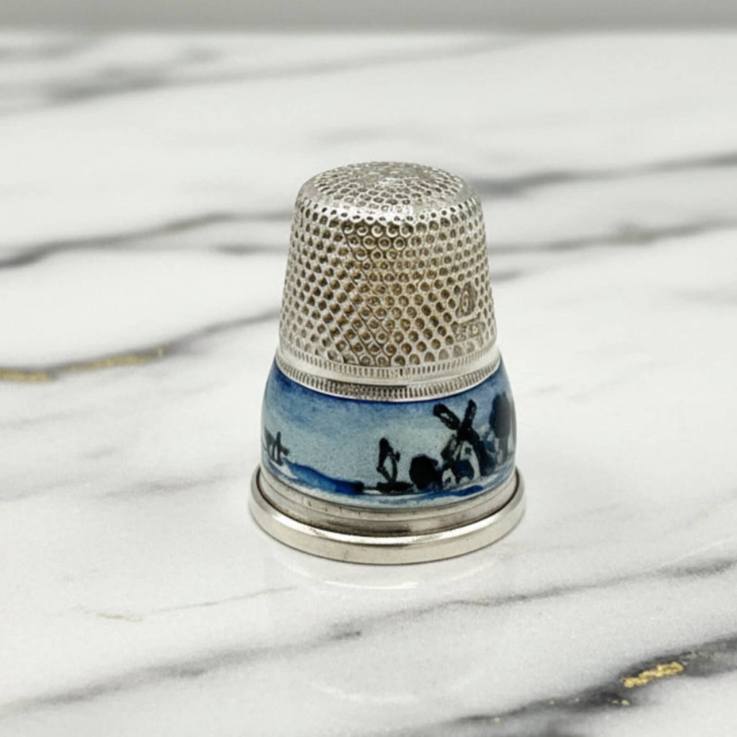 Thimble with decorative design on a marble surface