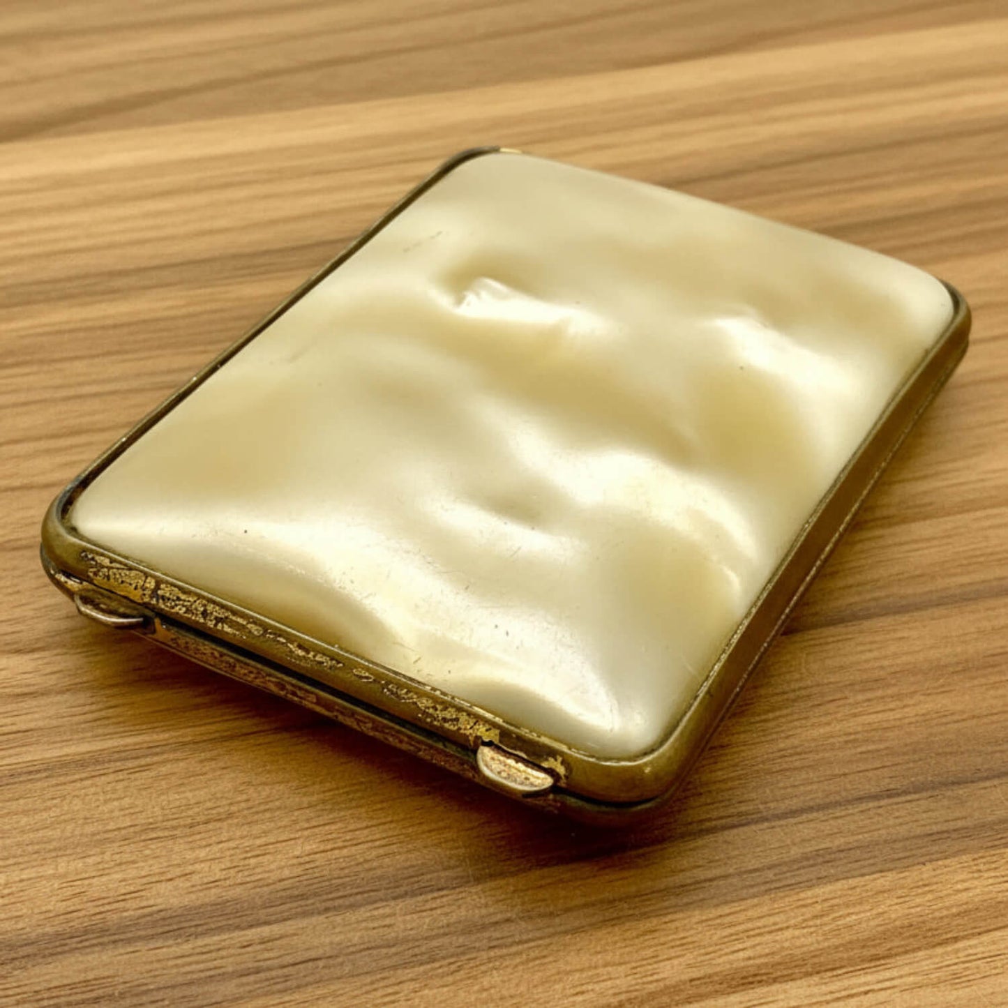 Vintage gold and cream-coloured case on a wooden surface