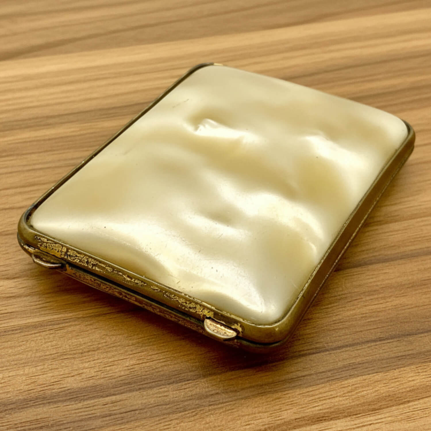 Vintage gold and cream-coloured case on a wooden surface