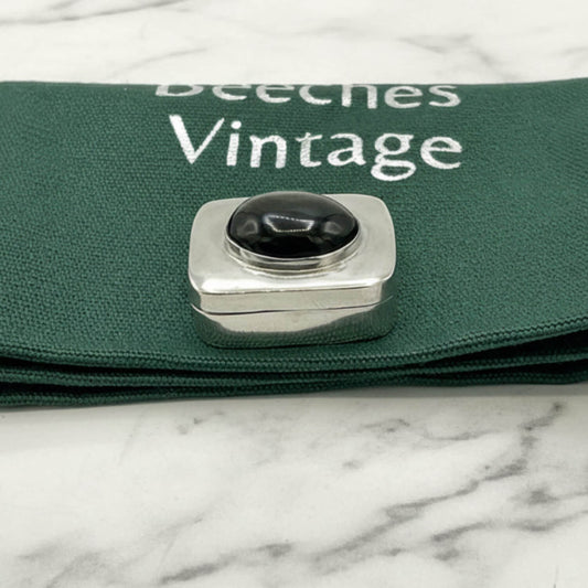 Vintage Black Gemstone Silver Pill Box on a green bag